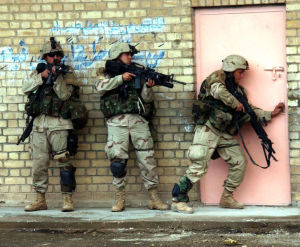美國陸軍第一騎兵師士兵正在掃蕩位在伊拉克費盧傑一棟廢墟房屋，攝於2004年11月12日。