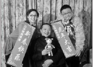 《五十塊錢》的主創尹北琛、周錦堂、李鐵（從左至右）拿著、叼著“笑笑虎”和條幅給本報讀者拜年呢
