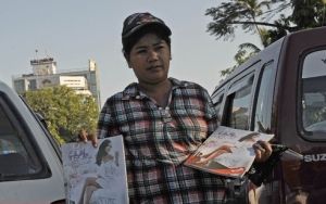一名緬甸婦女在仰光鬧市區兜售《迷醉》雜誌