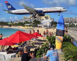 這架飛機離海灘地面只有幾米高，從這個角度看，飛機好像快要抵到一塊衝浪板。