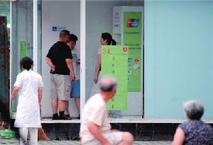 6月19日傍晚，不明情況的路人仍在使用“ATM機”，便衣警察上前勸說。 來源：京華時報 楊天嘯 攝