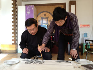 圖為學習冰雪山水畫期間與著名冰雪畫家李振東一同鑽研藝術創作