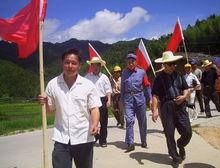 圖為參觀的隊伍走在石峰村的紅軍路上