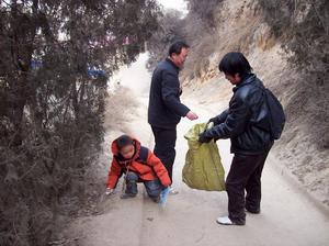 （圖）志願者一邊登上一邊撿垃圾