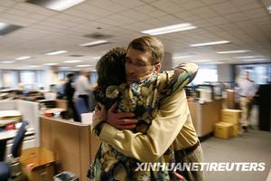 （圖）3月16日，在美國華盛頓州西雅圖，《西雅圖郵報》圖片編輯約翰•迪克森與工作人員克麗絲•貝林格擁抱
