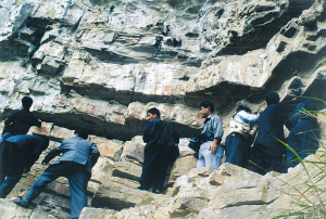 好奇的遊客爬上山崖，一睹岩畫風采