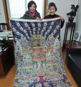 宋錦織造技藝國家級傳承人錢小萍（右）複製的“彩織西方極樂世界圖軸”