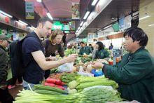 Tim與友人在杭州古盪農貿市場使用支付寶買菜