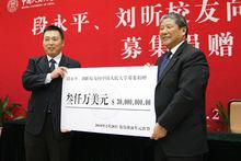 段永平向紀寶成校長(右)遞交捐贈支票