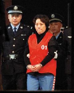 2009年10月15日22時許，謝才萍（中）被押解走出法庭。