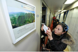    1月26日，旅客在“絲路驛站——寧夏號”列車上拍攝車廂內展示的塞上風光圖片。