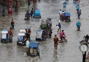 菲律賓居民從洪水中趟過