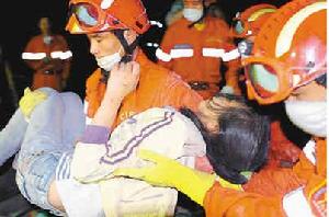 在東汽中學，國家救援隊隊員成功救出女學生馬曉鳳。圖為王念法抱著馬曉鳳走出廢墟。