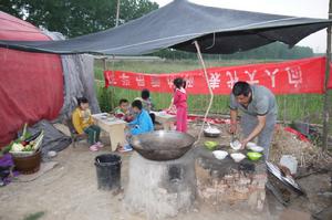 麥田爸爸在草棚露天廚房給腦癱患兒做飯