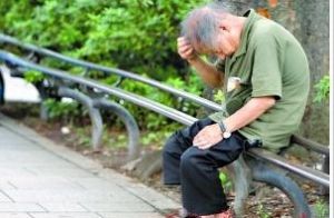 一名日本老人在東京街頭獨坐，抓頭髮消磨時間