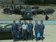 中國空軍飛行員捧獎盃在現代轎車前留影