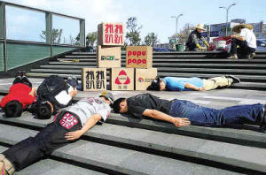 為瀋陽街頭一群年輕人趴在地上參與“趴街”。