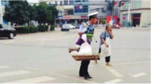 王明鋒幫老奶奶挑擔子過馬路。