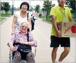 新生鄭宇的媽媽和他83歲的奶奶送孩子入學報到，志願者在搬運行李