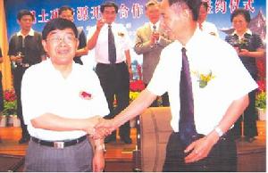 雲南冶金集團總公司董事長陳智（左）與鶴慶縣人民政府縣長段智深簽署協定後，親切握手