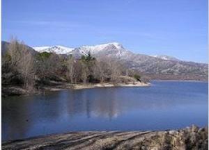 那瓦塞拉達水庫（Embalse de Navacerrada）和積雪覆蓋的瓜達拉馬山山頂。