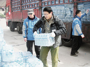 蘆沛然（中）為汶川地震受災民眾搬運飲用水
