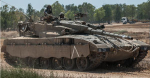 2014年7月16日，在以色列南部與加沙邊境，以軍士兵駕駛梅卡瓦坦克在田野中待命。