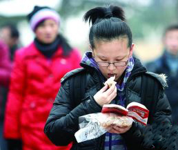 一名考生邊看書邊吃早飯