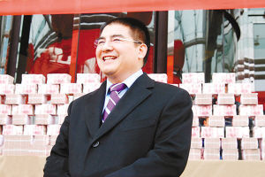 陳游標站在“錢牆”面前，笑容燦爛