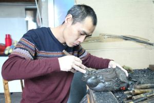 吳鵬大師正在聚精會神地雕刻煤精作品